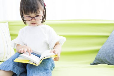 Küçük kız kitap okuyor.