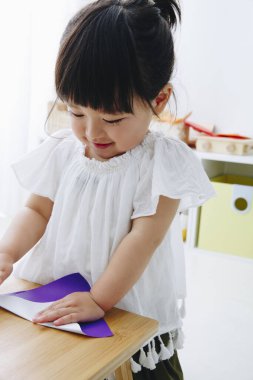 Oturma odasında oynayan küçük tatlı bir Japon kız.