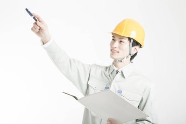 Beyaz arkaplanı gösteren Asyalı erkek mühendisin stüdyo portresi