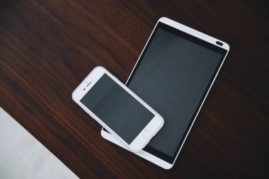 Ahşap arka planda modern akıllı telefon ve tablet