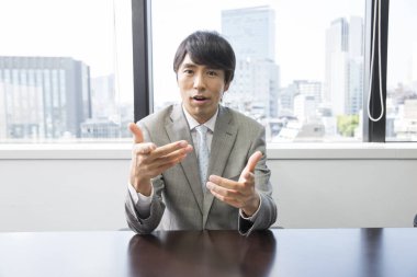 Asyalı işadamı ofiste konuşuyor.