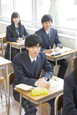 Genç Japon öğrenciler sınıfta okuyor.