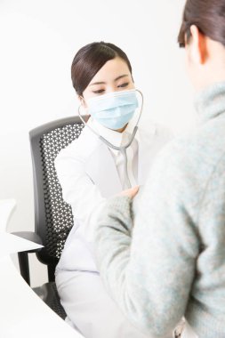 Doktor steteskopla hastayı kontrol ediyor.