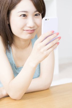 evde bir akıllı telefon kullanan kadın 