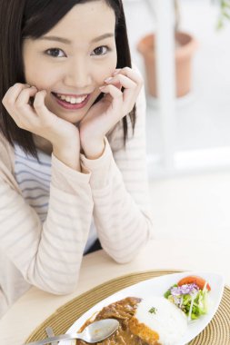 Genç Japon kadın restoranda yemek yiyor. 