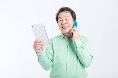 Beyaz arka planda tablet bilgisayarı ve cep telefonu olan Asyalı iş adamı.