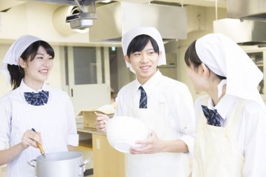 Öğrenciler mutfakta birlikte yemek pişiriyor.