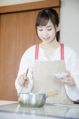 Güzel Asyalı kadın mutfakta yemek yapıyor.