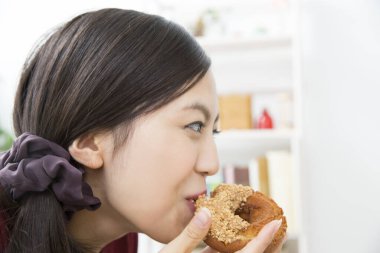 Asyalı kadın donuttan hoşlanıyor. 