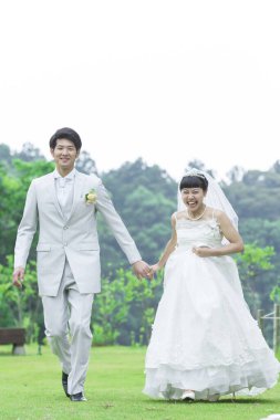 Parkta poz veren Asyalı gelin ve damat 