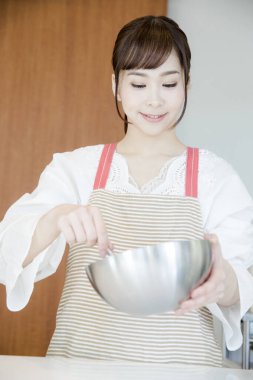 Güzel Asyalı kadın mutfakta yemek yapıyor.