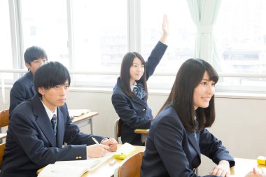 Genç Japon öğrenciler sınıfta okuyor.