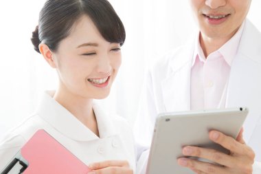 Genç Asyalı hemşire ve doktor hastane koğuşunda.