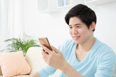 Evde cep telefonu olan bir adam.