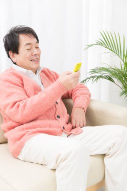 Cep telefonu kullanan Asyalı kıdemli adam.