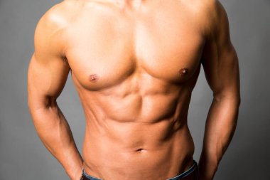 Kaslı vücutlu ve gömleksiz bir adamın portresi.