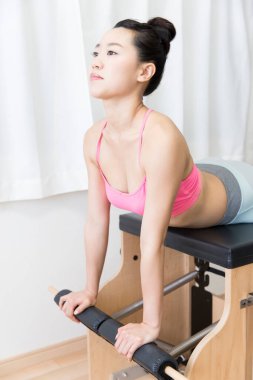 Spor giyinen Japon kadın iç mekanda antrenman yapıyor.