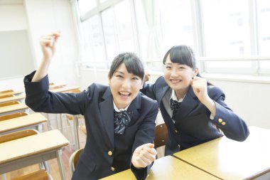 Asyalı öğrenciler sınıfta eğleniyor.