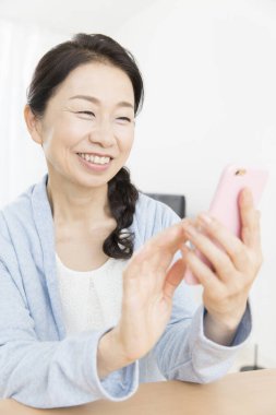 Kapat telefonu olan güzel, yaşlı Asyalı kadını.