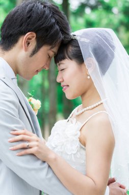 Parkta poz veren Asyalı gelin ve damat 