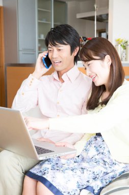 Genç Asyalı çift dizüstü evde kullanma 