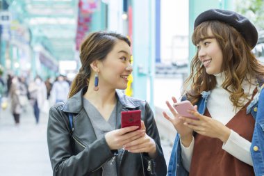 Şehirde cep telefonu kullanan Asyalı kadınlar