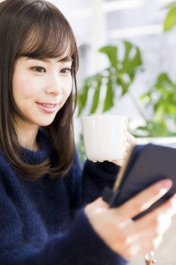 Tablet kullanan çekici Asyalı kadın portresi