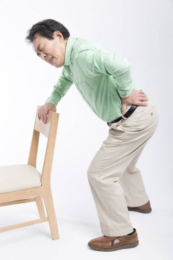 Sırt ağrısı çeken yaşlı bir Asyalı.