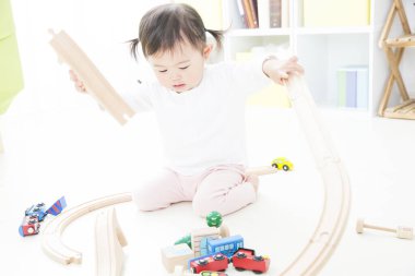 Asyalı küçük Çinli kız oyuncaklarla oynuyor.