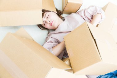 Yerde karton kutuları olan bir kadın. 