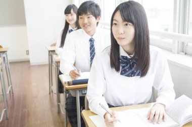 Genç Japon öğrenciler sınıfta okuyor.