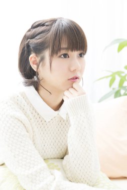 Beyaz kazaklı genç Japon kadın portresi televizyon izliyor. 