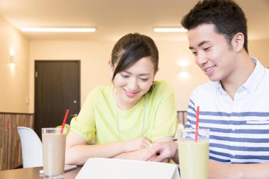 Kahve molasında tablete aşık Asyalı çift 