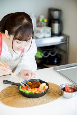 Kadın mutfakta Japon yemeği yiyor.