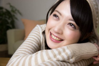 Evde gülümseyen ve televizyon izleyen bir kadın. 