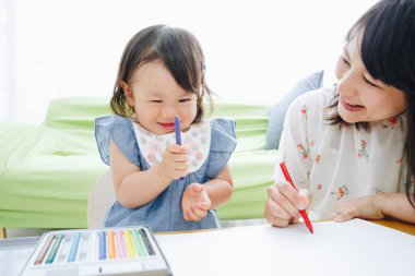 Annesiyle resim çizen tatlı Asyalı kız.