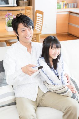 Evde uzaktan kumandalı Asyalı bir aile.