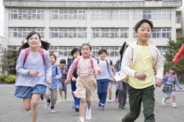 Dersten sonra eve koşan neşeli Asyalı öğrenciler.