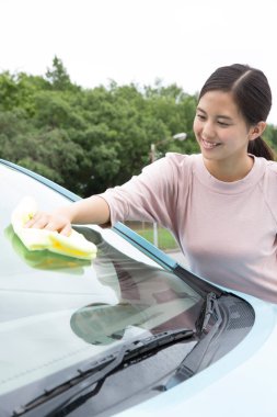 Arabasını dışarıda yıkayan gülümseyen Asyalı kadının portresi. 