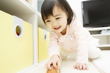 Küçük kız evde oyuncakla oynuyor. 