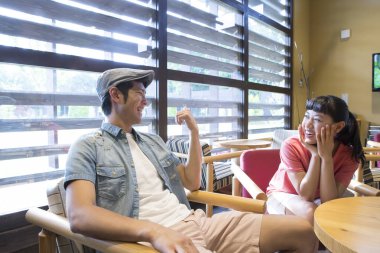 Kafede düzen bekleyen Asyalı bir çift var. 