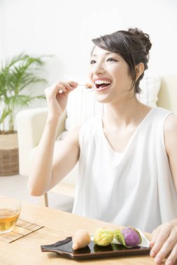 Evde kek yiyen genç bir kadın. 