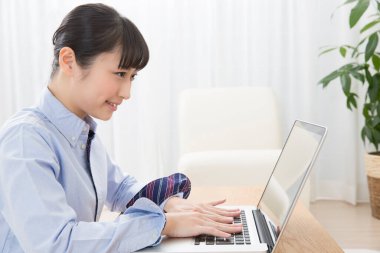 Laptop kullanan genç Asyalı kadın.