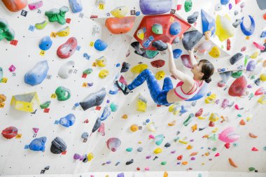 Güzel Japon kadın spor salonunda duvara tırmanıyor. 