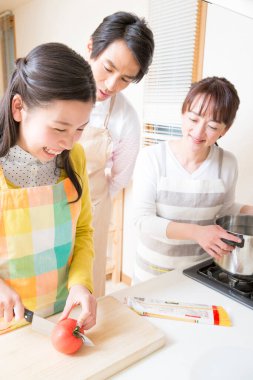 Asyalı aile mutfakta birlikte yemek pişiriyor.