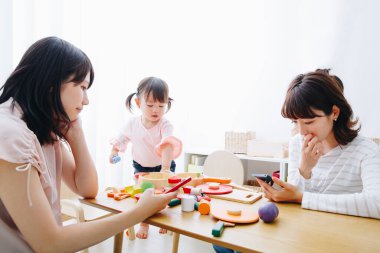 İki kadın ve çocuk oyuncaklarla oynuyor.