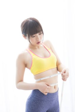 İnce Asyalı kadın belini ölçüyor, kilo verme konsepti.
