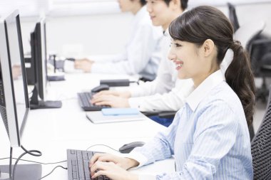 Ofisteki bilgisayarlarda çalışan genç iş adamları