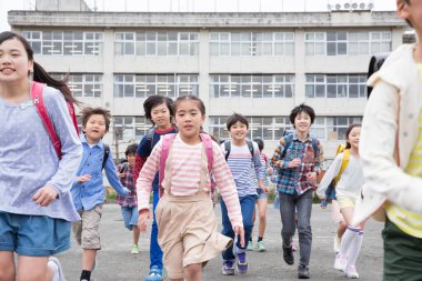 Dersten sonra eve koşan neşeli Asyalı öğrenciler.