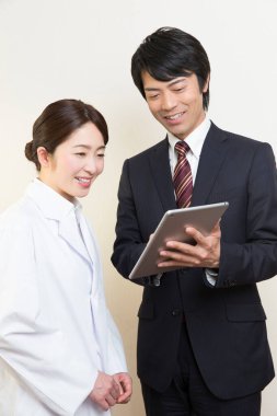 Tablet bilgisayar kullanan gülümseyen kadın doktor